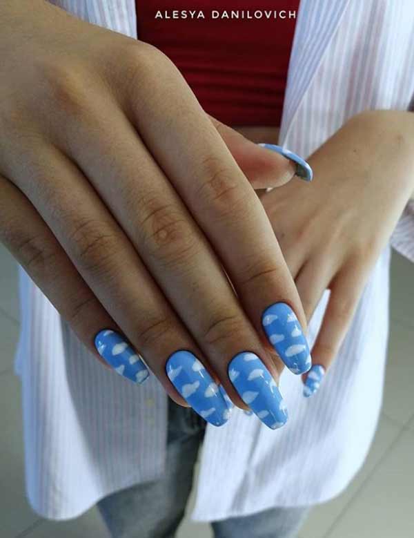 Blue manicure with white clouds