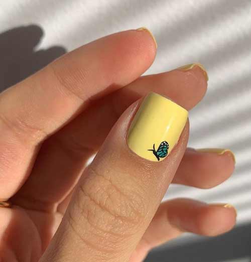 Yellow manicure with butterfly